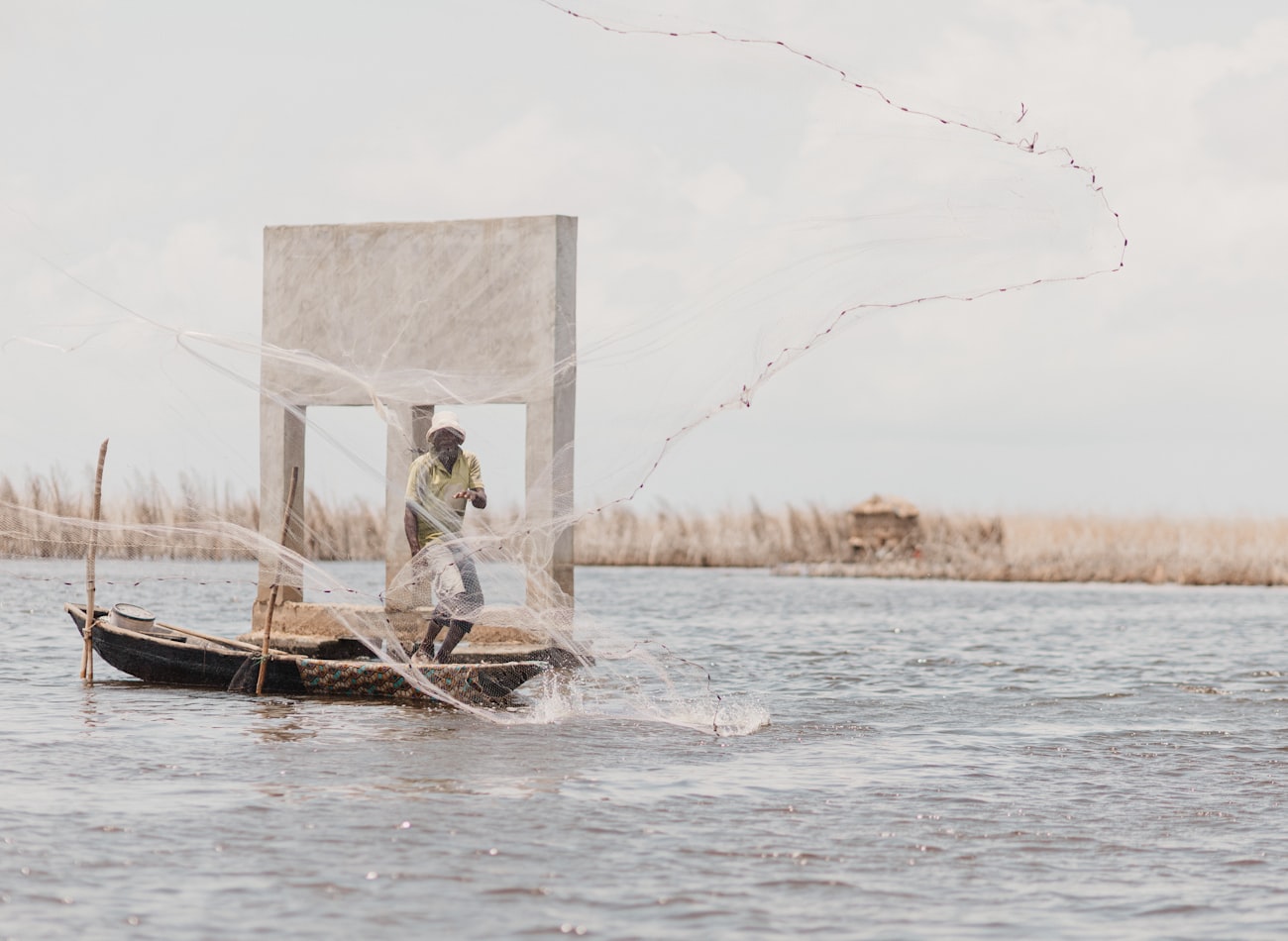 A fisherman casting his net from a boat